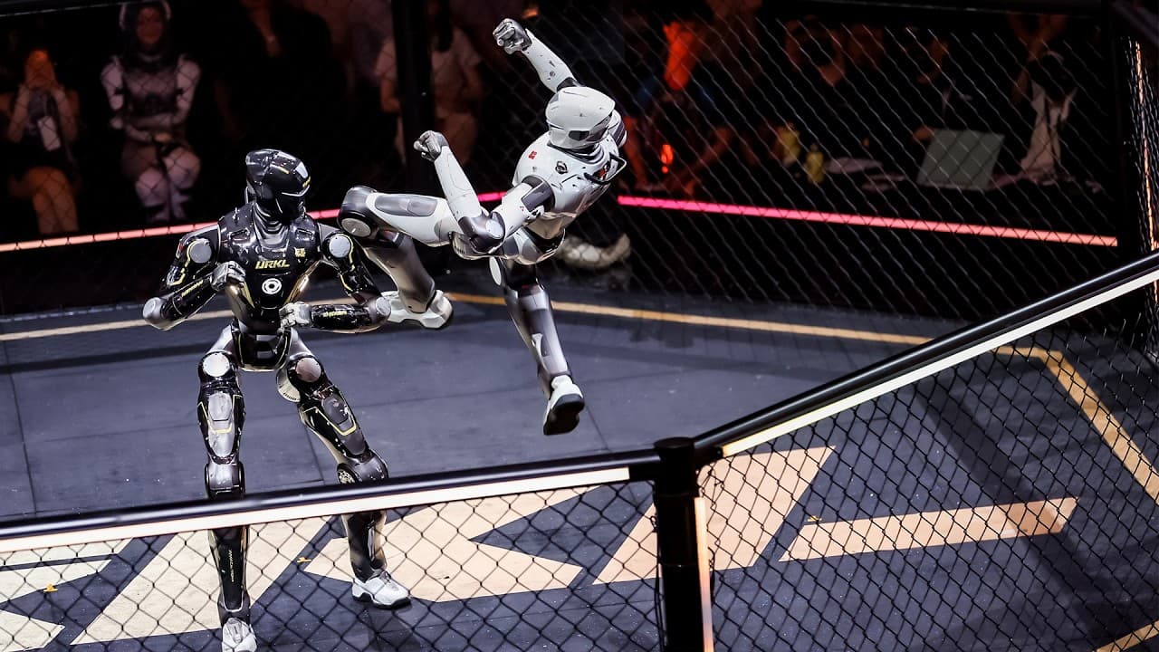 Matador's dark-armoured T800 facing the camera in the URKL cage while White Eagle attacks from the side